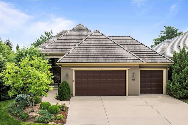 15027 Ash St, Leawood, KS 66224 - view of front of property with a garage, stucco siding, concrete driveway, and a tiled roof
