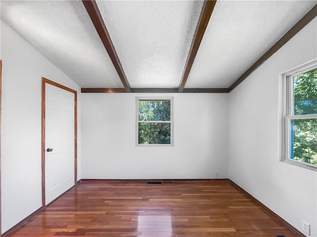 2939 Jewett St, Kansas City, MO 64117 - unfurnished bedroom featuring a textured ceiling, multiple windows, and wood finished floors