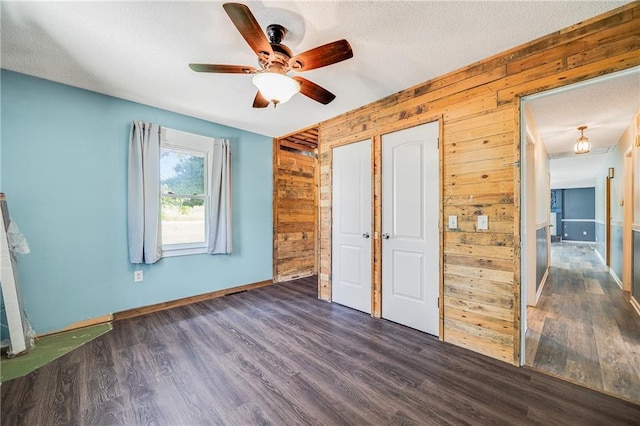 160 SW 131st Hwy, Holden, MO 64040 - unfurnished bedroom with wooden walls, wood finished floors, a textured ceiling, and a ceiling fan
