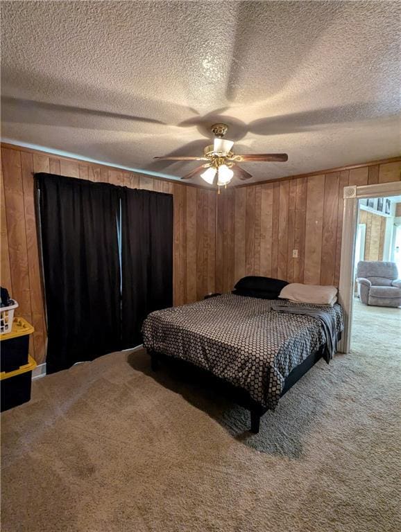 225 E 11th St, Horton, KS 66439 - carpeted bedroom with wooden walls, a textured ceiling, and a ceiling fan