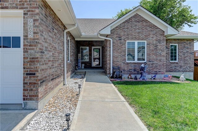 966 Moore Pl, Odessa, MO 64076 - view of exterior entry with a lawn, brick siding, and a shingled roof