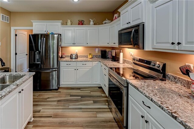 966 Moore Pl, Odessa, MO 64076 - kitchen with stainless steel appliances, white cabinetry, recessed lighting, and light stone countertops