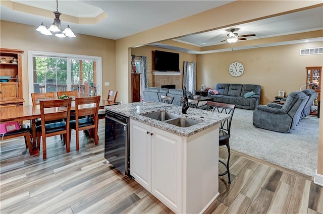 966 Moore Pl, Odessa, MO 64076 - kitchen with a tray ceiling, white cabinetry, light wood finished floors, a kitchen island with sink, and open floor plan