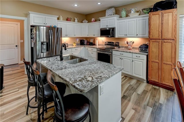 966 Moore Pl, Odessa, MO 64076 - kitchen featuring appliances with stainless steel finishes, recessed lighting, light wood finished floors, white cabinets, and light stone countertops