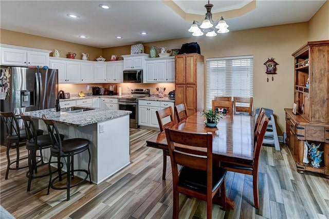 966 Moore Pl, Odessa, MO 64076 - kitchen with stainless steel appliances, recessed lighting, white cabinetry, a kitchen island with sink, and decorative light fixtures