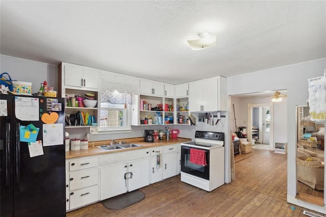 201 N Steuben Ave, Chanute, KS 66720 - kitchen featuring range with electric stovetop, freestanding refrigerator, open shelves, wood finished floors, and light countertops