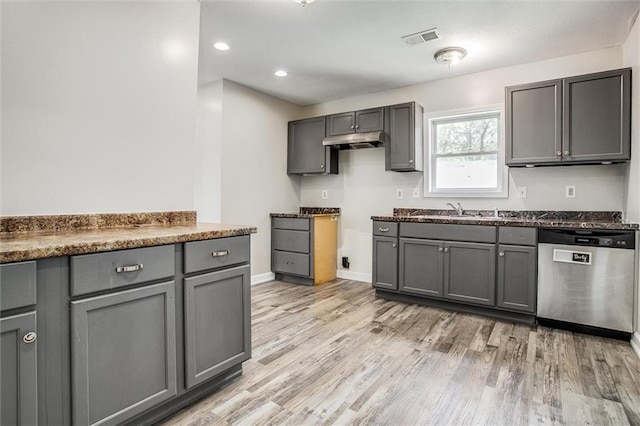 114 W 2nd St, Garden City, MO 64747 - kitchen with stainless steel dishwasher, gray cabinets, light wood-style flooring, a sink, and dark countertops