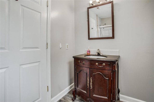 114 W 2nd St, Garden City, MO 64747 - bathroom with vanity, baseboards, and wood finished floors