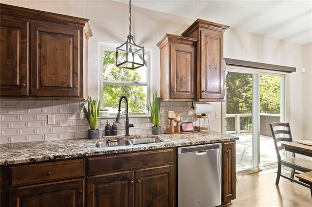 7907 W 59th Ter, Merriam, KS 66202 - kitchen featuring stainless steel dishwasher, healthy amount of natural light, decorative backsplash, and light stone countertops
