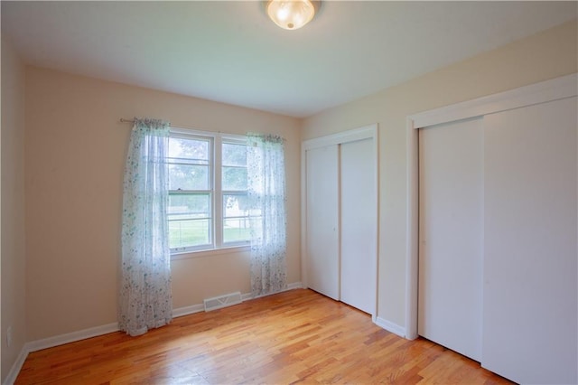 501 N Franklin St, Spring Hill, KS 66083 - unfurnished bedroom with two closets and light wood finished floors