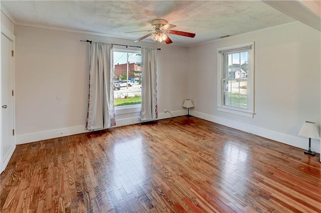 8 S Mulberry St, Louisburg, KS 66053 - empty room featuring plenty of natural light, a ceiling fan, wood finished floors, baseboards, and crown molding