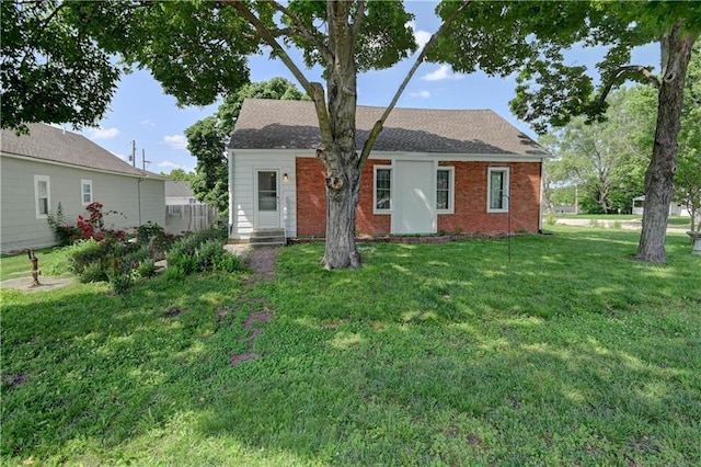 8 S Mulberry St, Louisburg, KS 66053 - view of front of house featuring a front yard, brick siding, and a shingled roof
