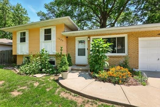 1203 S Skyline Dr, Liberty, MO 64068 - view of front facade with brick siding, an attached garage, and driveway