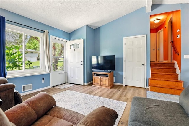 1203 S Skyline Dr, Liberty, MO 64068 - living area with light wood-type flooring, a textured ceiling, stairway, and lofted ceiling