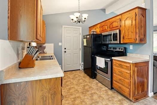 1203 S Skyline Dr, Liberty, MO 64068 - kitchen featuring stainless steel appliances, a chandelier, brown cabinets, and light countertops