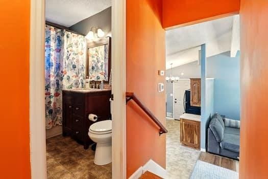 1203 S Skyline Dr, Liberty, MO 64068 - bathroom featuring vanity, vaulted ceiling, a chandelier, and a shower with curtain