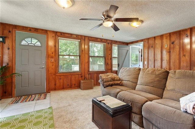 225 W Moore St, Independence, MO 64050 - living room featuring wooden walls, ceiling fan, a textured ceiling, and light tile patterned floors