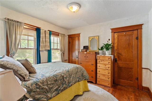 225 W Moore St, Independence, MO 64050 - bedroom with wood finished floors and a textured ceiling