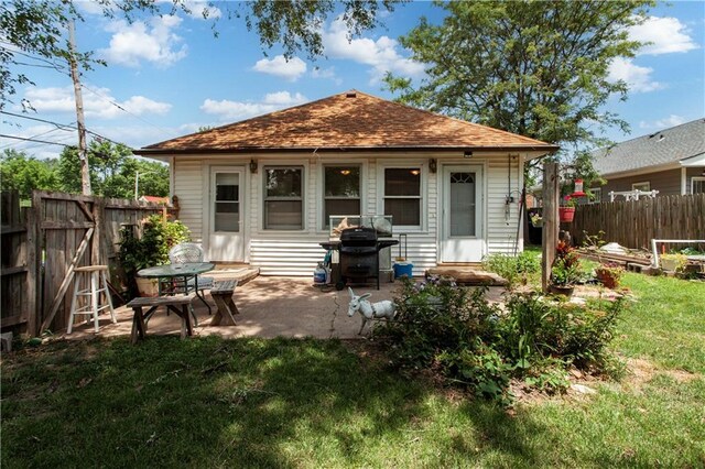225 W Moore St, Independence, MO 64050 - rear view of property featuring a fenced backyard, a shingled roof, and a patio