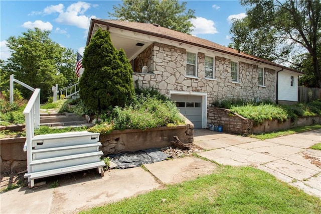 225 W Moore St, Independence, MO 64050 - view of front facade with stone siding, driveway, a garage, and stairs
