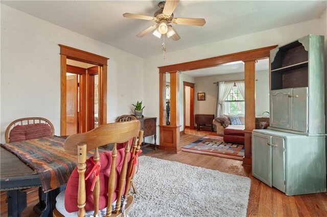 225 W Moore St, Independence, MO 64050 - dining area with decorative columns, wood finished floors, and a ceiling fan