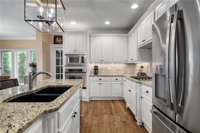 14208 Larsen St, Overland Park, KS 66221 - kitchen with stainless steel appliances, ornamental molding, white cabinetry, dark wood-type flooring, and decorative backsplash