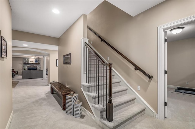 14208 Larsen St, Overland Park, KS 66221 - stairway with carpet flooring, arched walkways, a fireplace, and recessed lighting