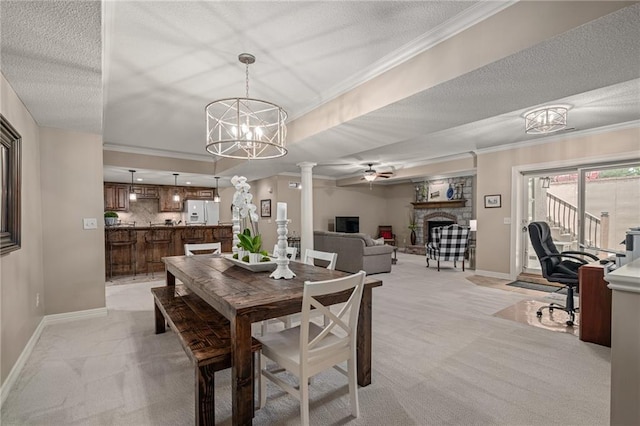 14208 Larsen St, Overland Park, KS 66221 - dining area featuring a fireplace, light carpet, ornate columns, a chandelier, and ceiling fan