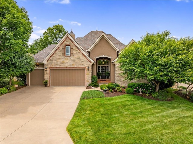 14208 Larsen St, Overland Park, KS 66221 - view of front of home with stone siding, driveway, a front yard, stucco siding, and an attached garage