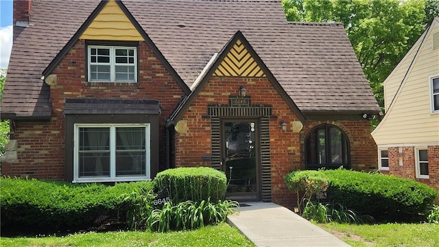 6645 Cherry St, Kansas City, MO 64131 - tudor-style house featuring brick siding, a shingled roof, and a chimney