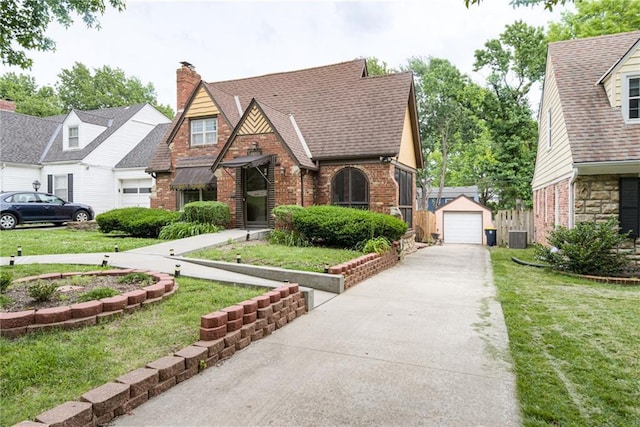 6645 Cherry St, Kansas City, MO 64131 - tudor home featuring brick siding, a detached garage, and a front yard