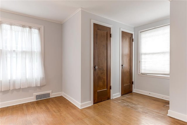 6645 Cherry St, Kansas City, MO 64131 - spare room featuring light wood-style flooring, crown molding, and plenty of natural light