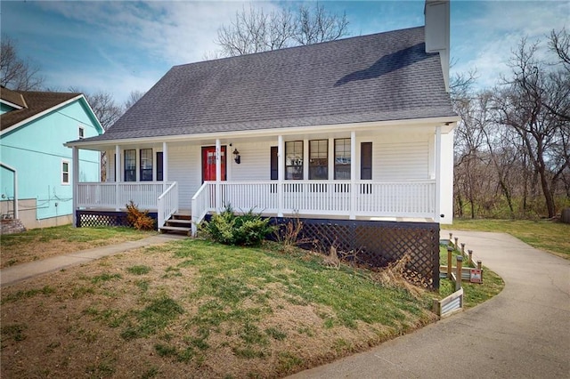 334 Fawn Valley Ct, Lansing, KS 66043 - view of front of home with covered porch, a shingled roof, a front lawn, and a chimney