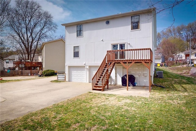 334 Fawn Valley Ct, Lansing, KS 66043 - back of house featuring an attached garage, stairway, concrete driveway, a wooden deck, and cooling unit