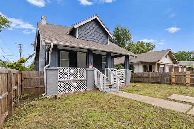 5701 Wabash Ave, Kansas City, MO 64130 - bungalow featuring a chimney, roof with shingles, and covered porch