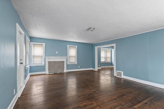 5701 Wabash Ave, Kansas City, MO 64130 - unfurnished living room with hardwood / wood-style flooring, a textured ceiling, baseboards, and a fireplace with flush hearth