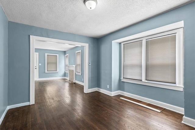 5701 Wabash Ave, Kansas City, MO 64130 - spare room featuring wood-type flooring, baseboards, and a textured ceiling