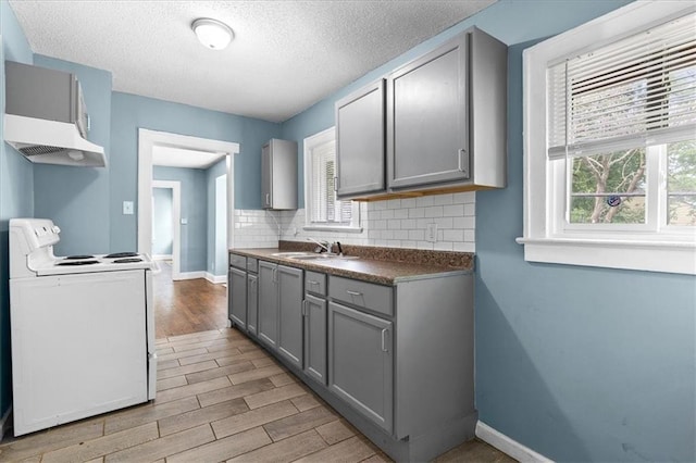 5701 Wabash Ave, Kansas City, MO 64130 - kitchen featuring white range with electric stovetop, gray cabinets, light wood finished floors, a sink, and baseboards