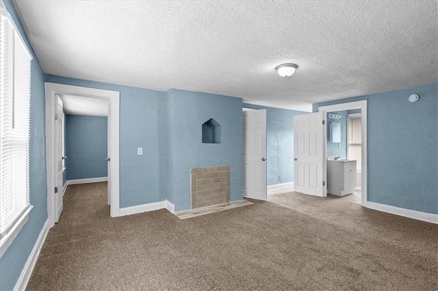 5701 Wabash Ave, Kansas City, MO 64130 - unfurnished bedroom with carpet floors, a textured ceiling, a textured wall, and baseboards