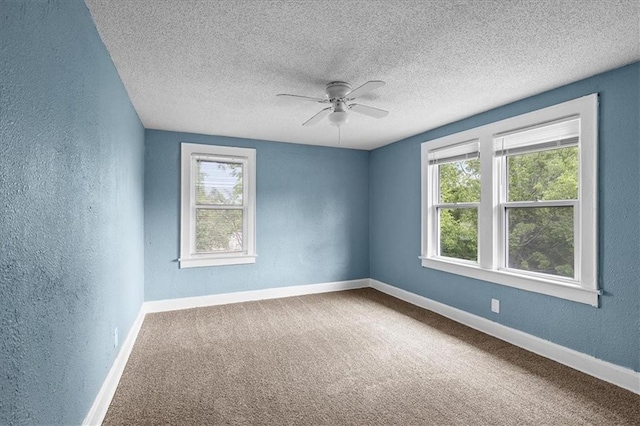 5701 Wabash Ave, Kansas City, MO 64130 - unfurnished room featuring a textured wall, healthy amount of natural light, a ceiling fan, a textured ceiling, and baseboards