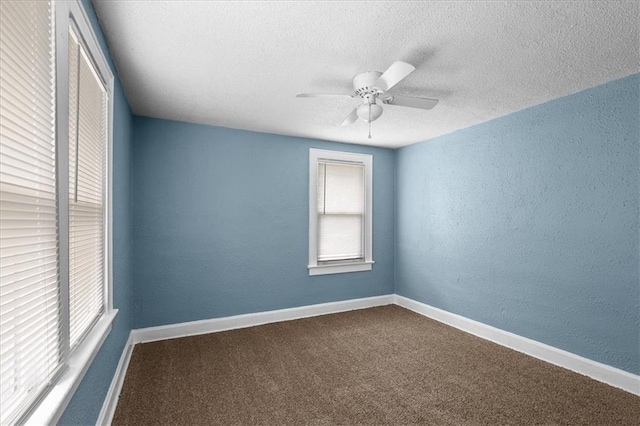 5701 Wabash Ave, Kansas City, MO 64130 - spare room featuring a textured ceiling, a textured wall, ceiling fan, carpet, and baseboards
