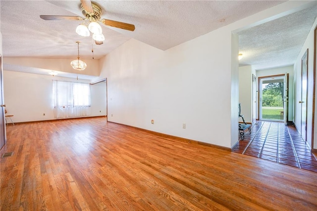 1110 E 1600th Rd, Lawrence, KS 66046 - empty room with a textured ceiling, healthy amount of natural light, wood finished floors, lofted ceiling, and ceiling fan