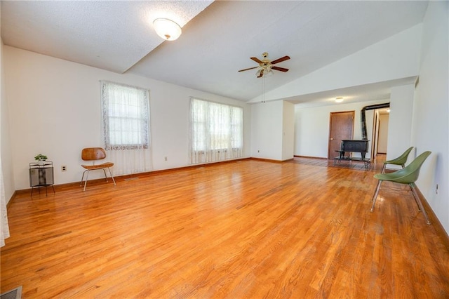1110 E 1600th Rd, Lawrence, KS 66046 - unfurnished living room featuring vaulted ceiling, ceiling fan, light wood-type flooring, and a wood stove