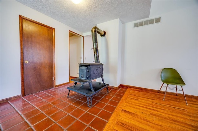 1110 E 1600th Rd, Lawrence, KS 66046 - tiled living room with a wood stove and a textured ceiling