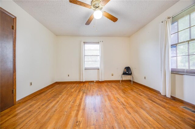 1110 E 1600th Rd, Lawrence, KS 66046 - unfurnished room with light wood finished floors, a textured ceiling, a ceiling fan, and baseboards