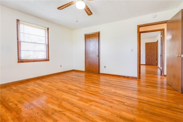 1110 E 1600th Rd, Lawrence, KS 66046 - empty room featuring light wood-type flooring, a ceiling fan, baseboards, and a textured ceiling