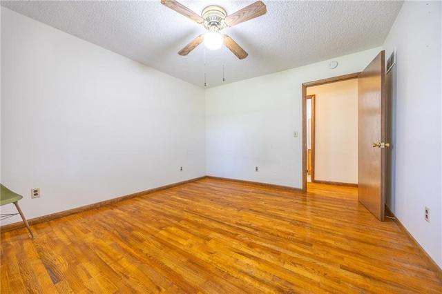 1110 E 1600th Rd, Lawrence, KS 66046 - empty room featuring light wood finished floors, ceiling fan, a textured ceiling, baseboards, and a smoke detector