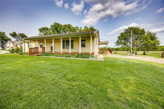 1110 E 1600th Rd, Lawrence, KS 66046 - view of front of house featuring a porch, a front lawn, and a chimney