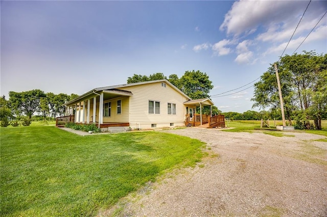 1110 E 1600th Rd, Lawrence, KS 66046 - view of home's exterior with a porch, a lawn, and gravel driveway