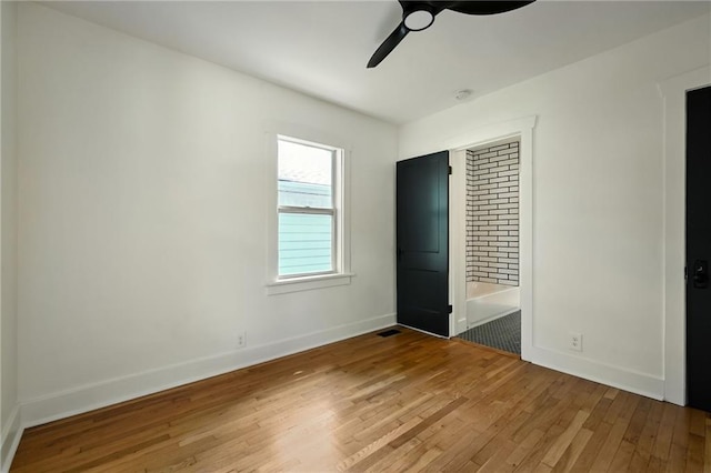 1220 E 24th Ave, Kansas City, MO 64116 - unfurnished bedroom featuring wood finished floors, baseboards, and ceiling fan